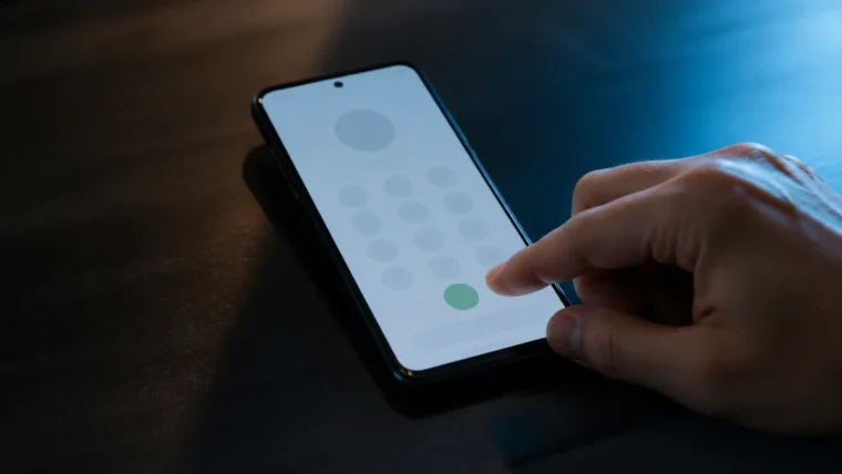 Telefon ekranındaki soyut çeviriciye dokunmadan önce bekleyen elden oluşan yazısız teknoloji sahnesi