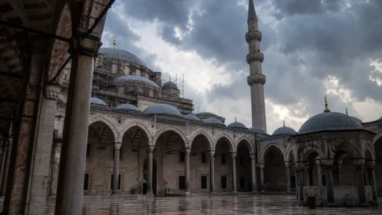 İstanbul tarihî cami minaresi, yağmur sonrası bakım sahnesi, yazısız editoryal görsel
